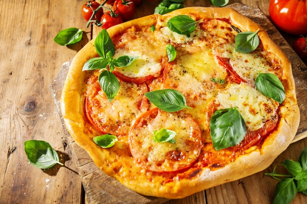 Selbst gemachte Pizza mit Mozzarella auf hölzernem Hintergrund