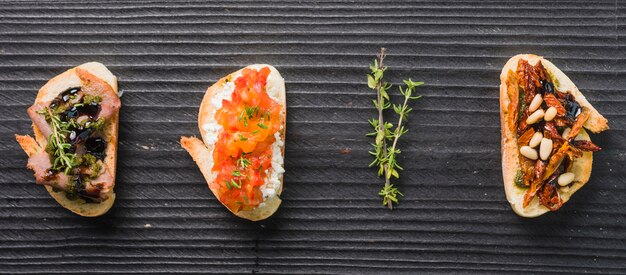 Selbst gemachte Toastsandwiche mit Thymian auf hölzernem schwarzem Hintergrund