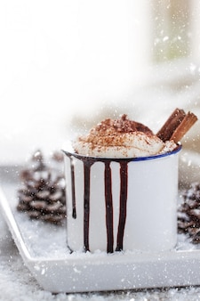 Selbst gemachte weihnachtsheiße schokolade mit schlagsahne, kakao und zimt auf einer platte in der weihnachtsfeiertagsatmosphäre