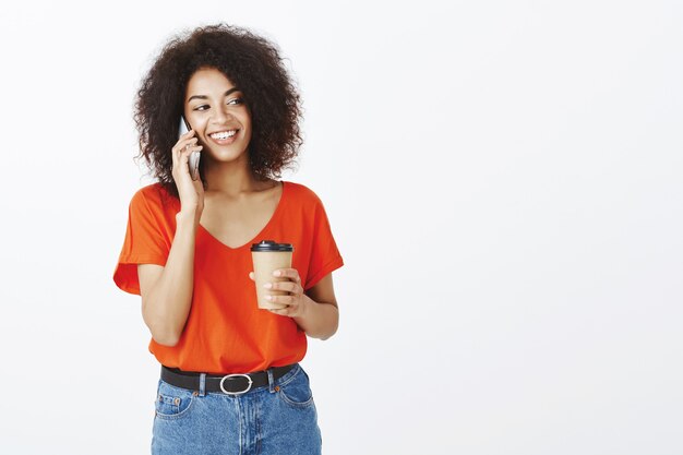 Selbstbewusste Frau mit Afro-Frisur, die im Studio aufwirft