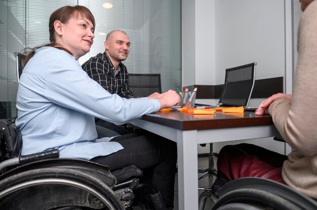 Selbstbewusste Geschäftsfrau im Rollstuhl am Schreibtisch