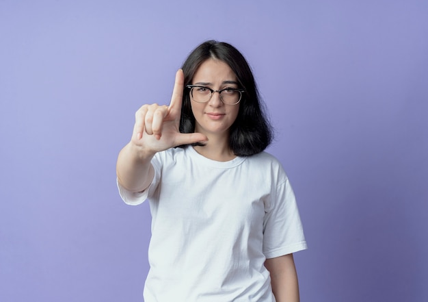 selbstbewusste junge hübsche Frau mit Brille, die vorne eine Verlierergeste macht