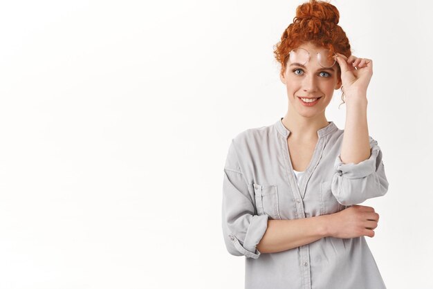 Selbstbewusste, stilvolle, gutaussehende Frau mit lockiger roter Frisur, Startbrille und lächelndem, durchsetzungsfähigem Querarm, der selbstbewusst und durchsetzungsfähig aussieht, zufrieden aussehendes Endergebnis des Projekts