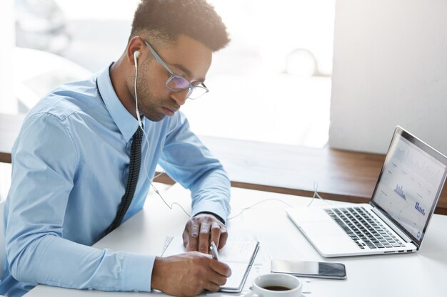 Selbstbewusster Geschäftsmann, der an seinem Laptop arbeitet