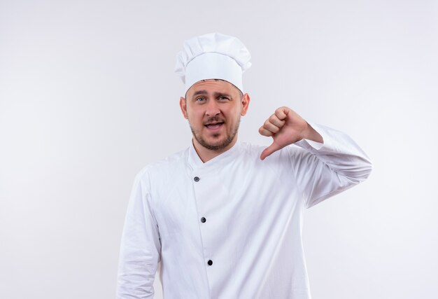 Selbstbewusster junger gutaussehender Koch in Kochuniform, der auf sich selbst zeigt, isoliert auf weißer Wand