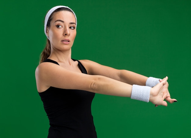 Kostenloses Foto selbstbewusstes junges hübsches sportliches mädchen mit stirnband und armbändern