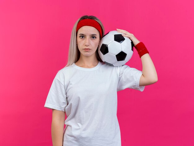 Selbstbewusstes junges kaukasisches sportliches Mädchen mit Klammern, die Stirnband tragen