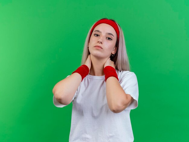 Selbstbewusstes junges kaukasisches sportliches Mädchen mit Klammern, die Stirnband tragen