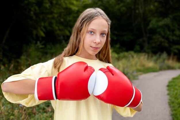 Selbstbewusstes Mädchen mit Boxhandschuhen