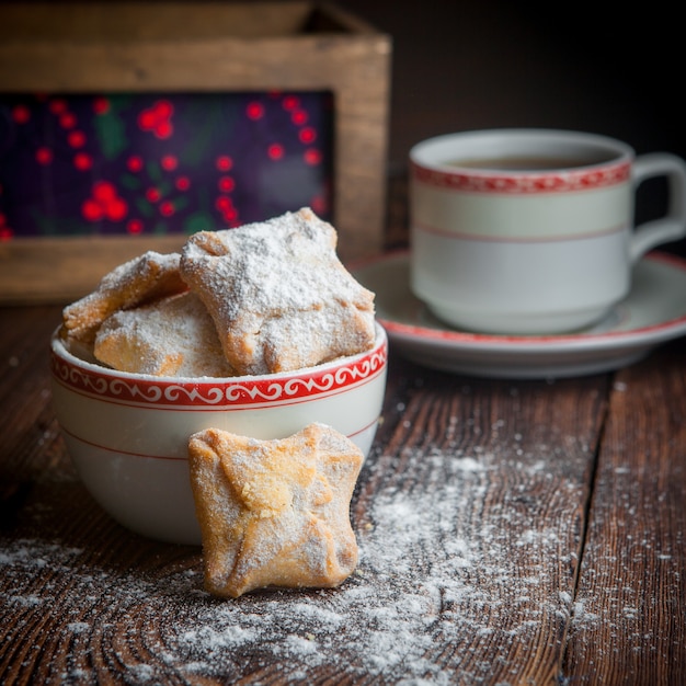 Selbstgemachtes Backen der Nahaufnahme mit Tasse Tee, Süßigkeiten und Beeren auf Holztisch