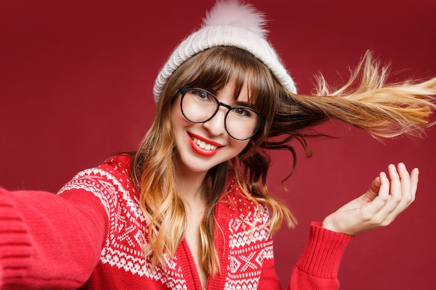 Selbstporträt der glücklichen langhaarigen Frau in der Winterkleidung
