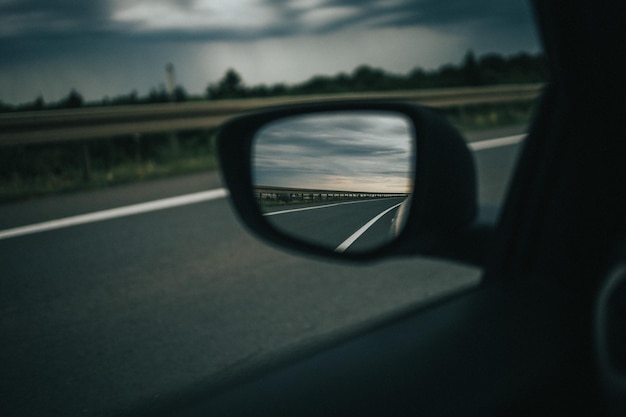 Kostenloses Foto selektive fokusaufnahme der autobahnreflexion auf einem autoseitenspiegel