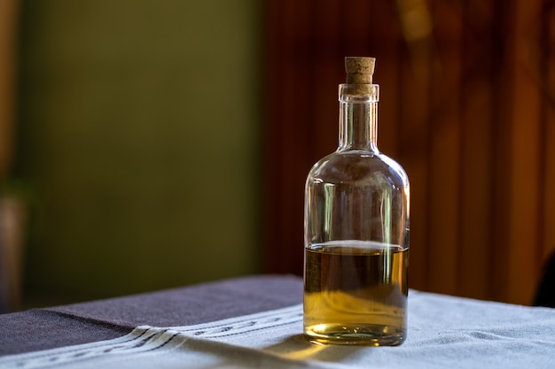 Selektive Fokusaufnahme einer Flasche Tequila auf einem Tisch mit Grat