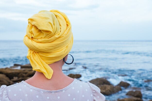 Selektive Fokusaufnahme einer jungen Frau, die sich am Meer entspannt