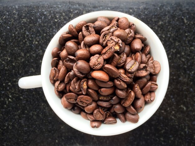 Selektive Kaffeebohnen in großer Kaffeetasse. Selektiv fokussiert.