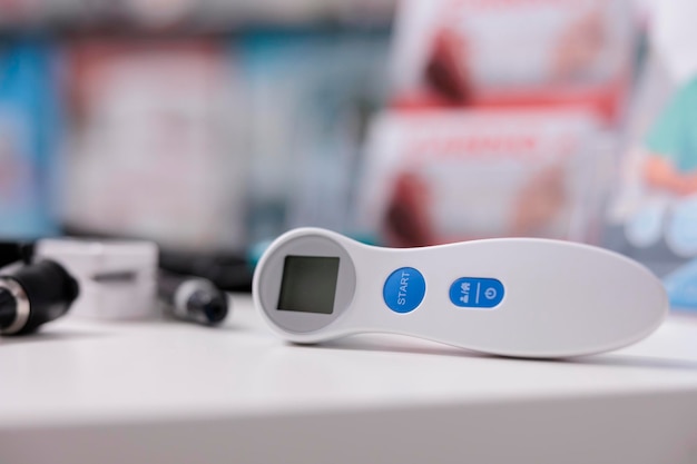 Kostenloses Foto selektiver fokus auf medizinisches thermometer, das in leerer apotheke auf dem tisch steht, medizinische instrumente, die von fachleuten verwendet werden können. drogerie mit pharmazeutischen produkten, vitaminen und medikamenten ausgestattet