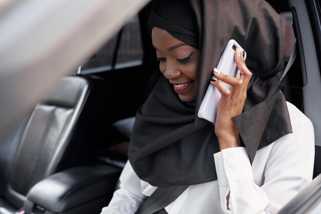 Selektiver Fokus eines islamischen Mädchens im Hijab, das im Auto sitzt