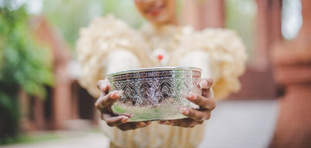 Selektiver Fokus Weibliche Hände halten eine Wasserschüssel in Tempeln und bewahren die gute Kultur der Thailänder während des Songkran-Festivals Thai-Neujahrs-Familientag im April