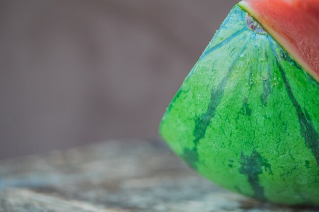 Selektiver Fokusschuss der Nahaufnahme von geschnittenen Wassermelonenstücken auf einem grauen hölzernen Hintergrund