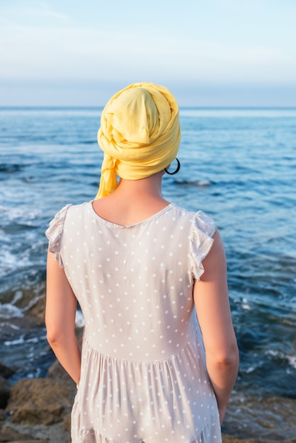 Selektiver Fokusschuss einer jungen Frau, die sich am Meer entspannt