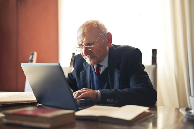 Selektiver Fokusschuss eines älteren kaukasischen Mannes, der an einem Laptop arbeitet