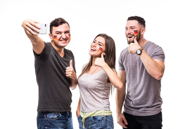 Selfie am Telefon des deutschen Fußballfans in der Spielunterstützung der deutschen Nationalmannschaften auf weißem Hintergrund. Fußballfans Konzept.