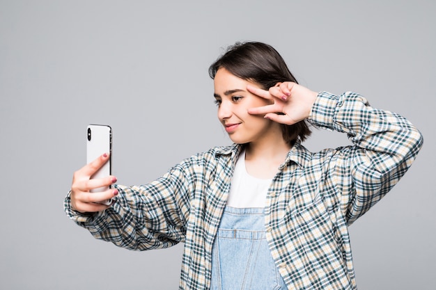 Selfie Zeit. Freudige junge Frauen machen Selfie durch ihr Smartphone isoliert