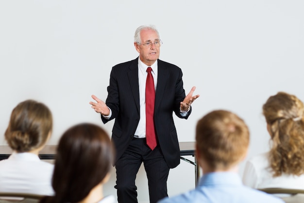 Kostenloses Foto senior business-mann geben einen vortrag