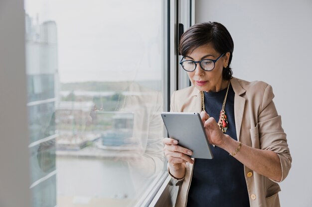 Senior, der einen mittleren Schuss der Tablette hält