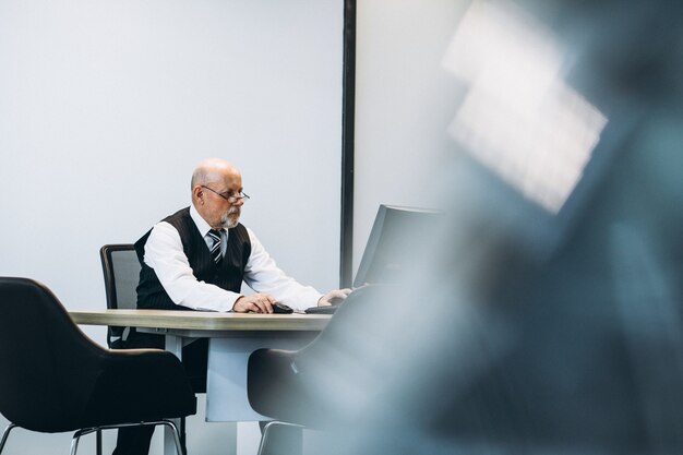 Senior Manager im Büro, das an einem Computer arbeitet