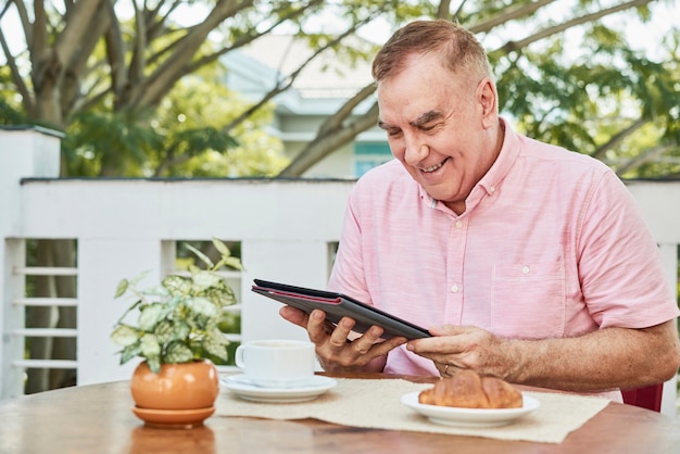 Senior Mann liest Nachrichten