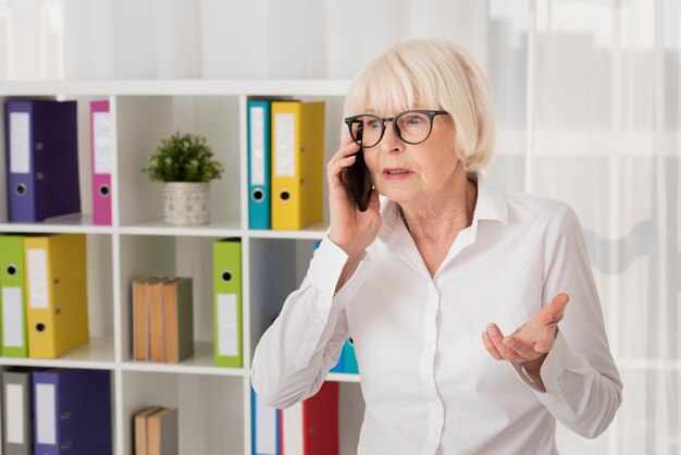 Senior mit Brille am Telefon sprechen