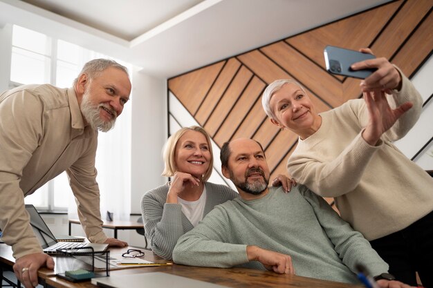 Senioren in der Schule machen ein Selfie mit dem Smartphone