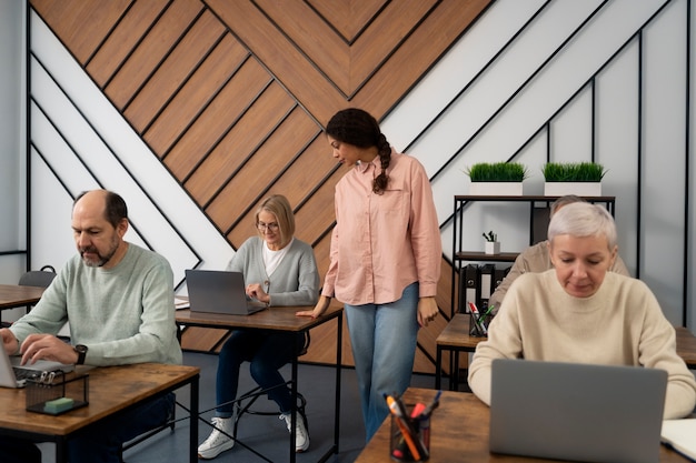 Senioren in der Schule während des Unterrichts mit Laptop-Computer