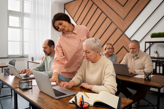 Senioren in der Schule während des Unterrichts mit Laptop-Computer