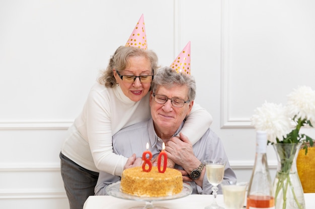Seniorenpaar mit mittlerer aufnahme, das geburtstag feiert