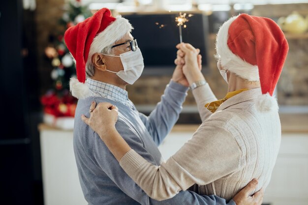 Seniorenpaar tanzt während der Weihnachtsfeier zu Hause während der COVID19-Pandemie