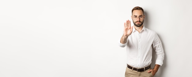 Seriöser Chef mit Brille, der ein Stoppschild zeigt, das nichts verbietet, das über weißem Backgr steht