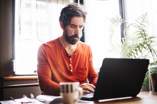 Serious Mann mit Laptop am Arbeitsplatz