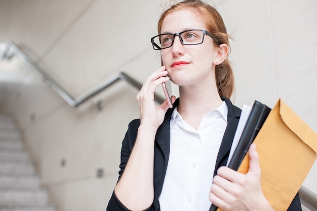 Kostenloses Foto serious student telefoniert auf treppenhaus