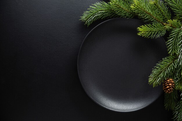 Serviert weihnachtliche Tischdekoration in dunklen Tönen. Dunkle Platte auf dunklem Hintergrund