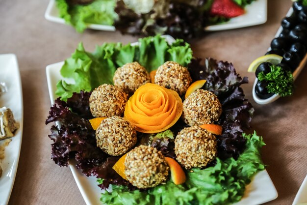 Sesambällchen mit Salat, Orange und Oliven