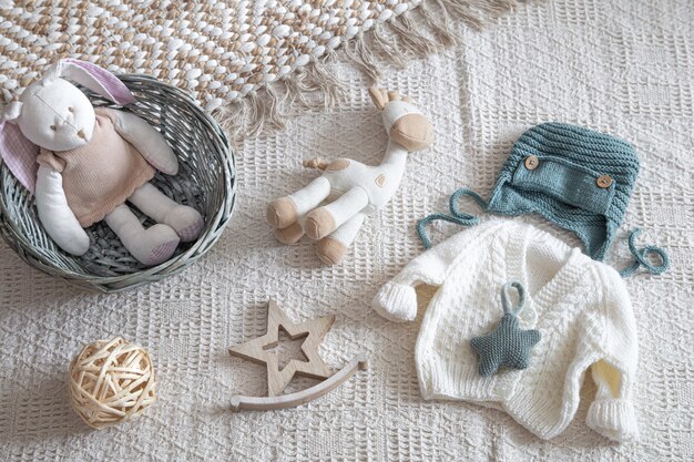 Set stilvolle handgefertigte Strickkleidung für Kinder mit verschiedenen Accessoires im Boho-Stil, Draufsicht.