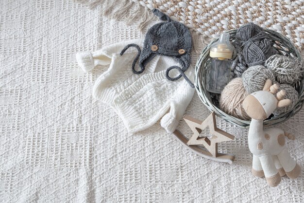 Set stilvolle handgefertigte Strickkleidung für Kinder mit verschiedenen Accessoires im Boho-Stil, Draufsicht.