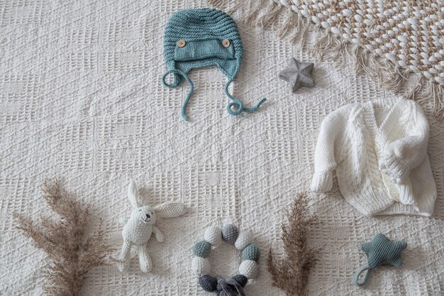 Set stilvolle handgefertigte Strickkleidung für Kinder mit verschiedenen Accessoires im Boho-Stil, Draufsicht.