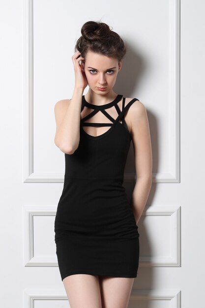 Sexy junge Frau, die mit schwarzem Kleid aufwirft