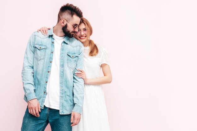 Sexy lächelnde schöne Frau und ihr hübscher Freund Fröhliche, fröhliche Familie, die zärtliche Momente in der Nähe der Wand im Studio hat