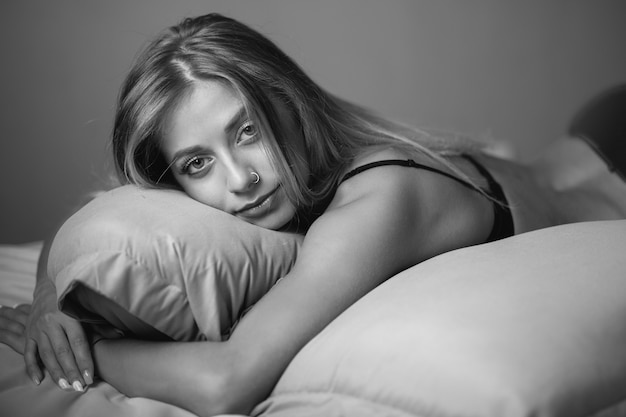 Sexy schöne blondine, die im bett liegen