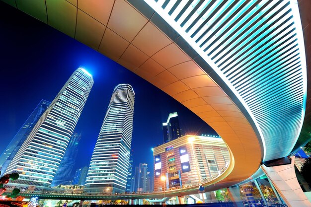 Shanghai bei Nacht mit städtischem Wolkenkratzer und modernem Stadtbild auf der Straße.
