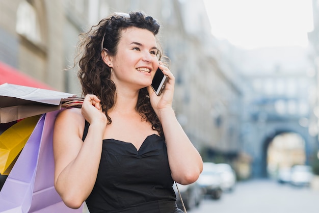 Kostenloses Foto shopaholic frau, die am handy spricht